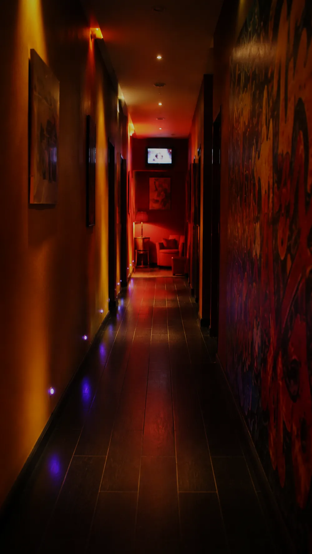 Un couloir de l'étage du Prado, éclairage tamisé rouge et ambre